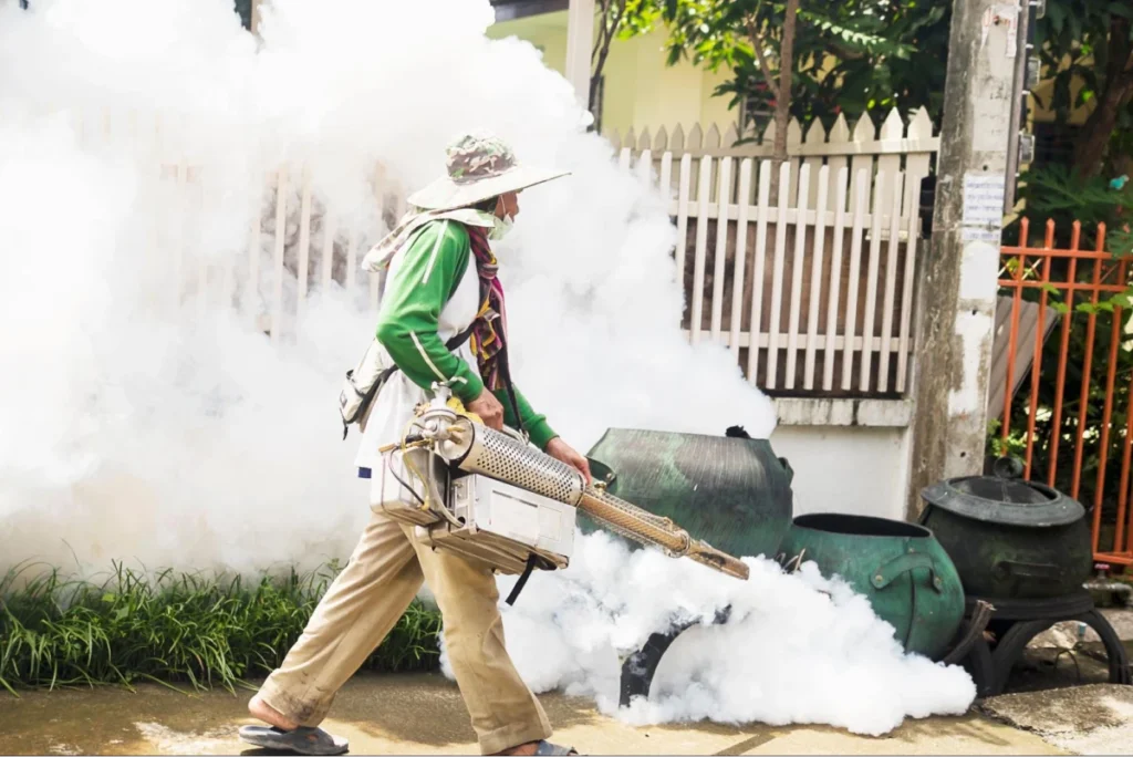 Worker fumigating area with fogger.